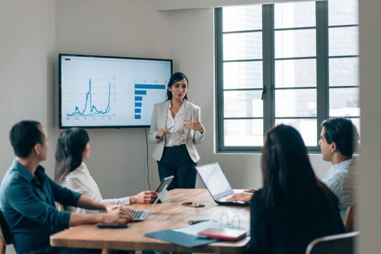 Woman giving presentation in a small conference room.