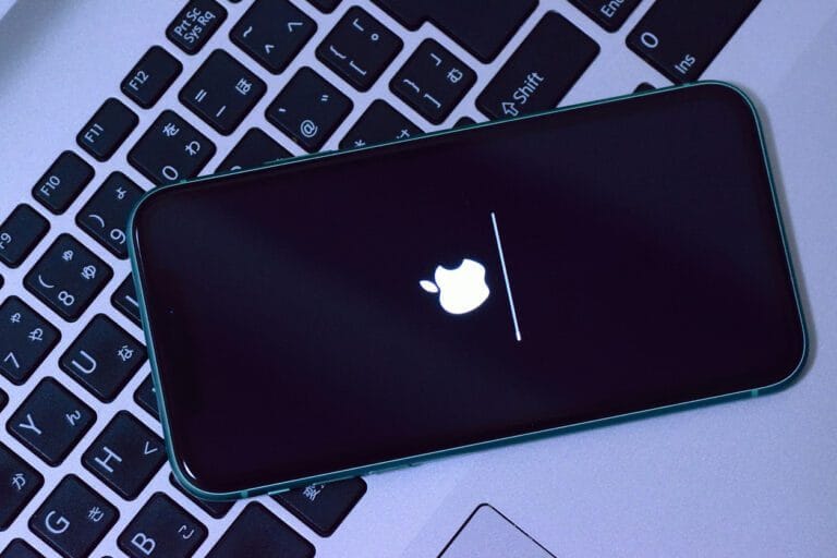IOS 7 phone laying on laptop.