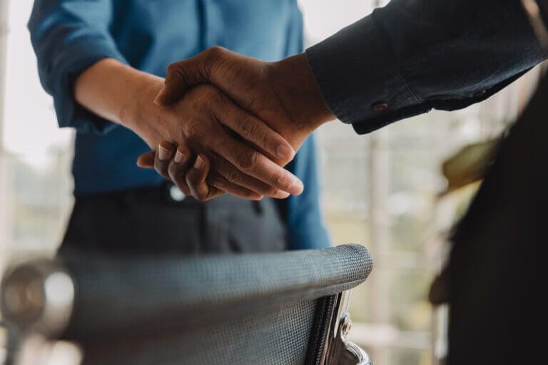 IT staff and employees shaking hands in an office.
