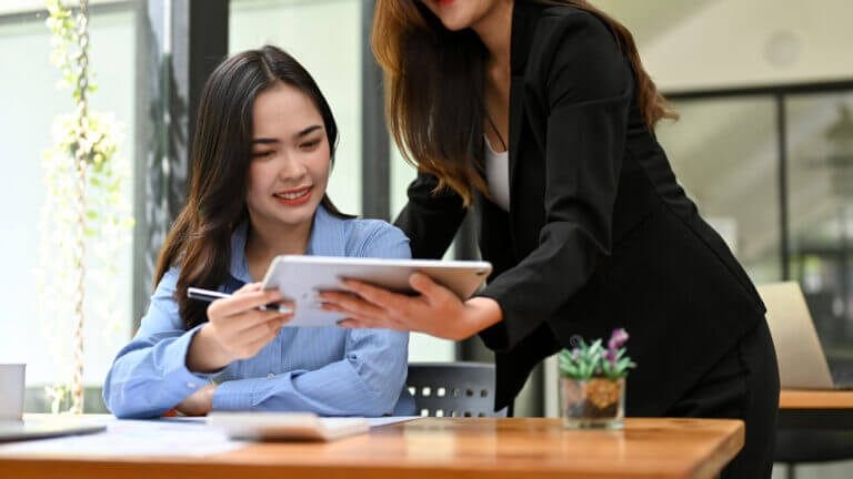 Professional women reviewing items on an ipad.