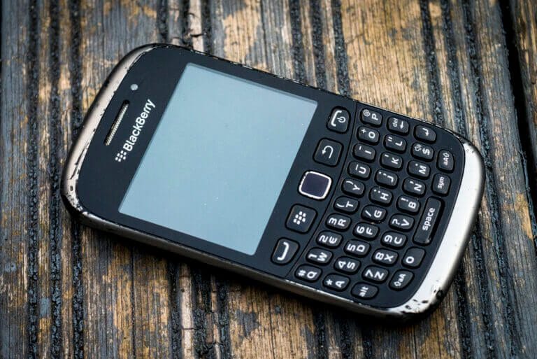 Old BlackBerry on a wood table.