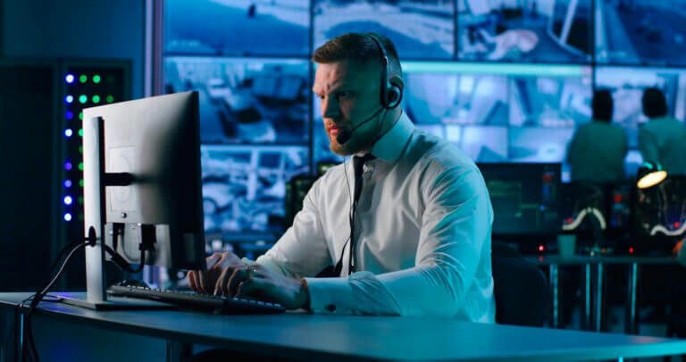 IT staff with headset working with clients over the phone on cybersecurity issues.