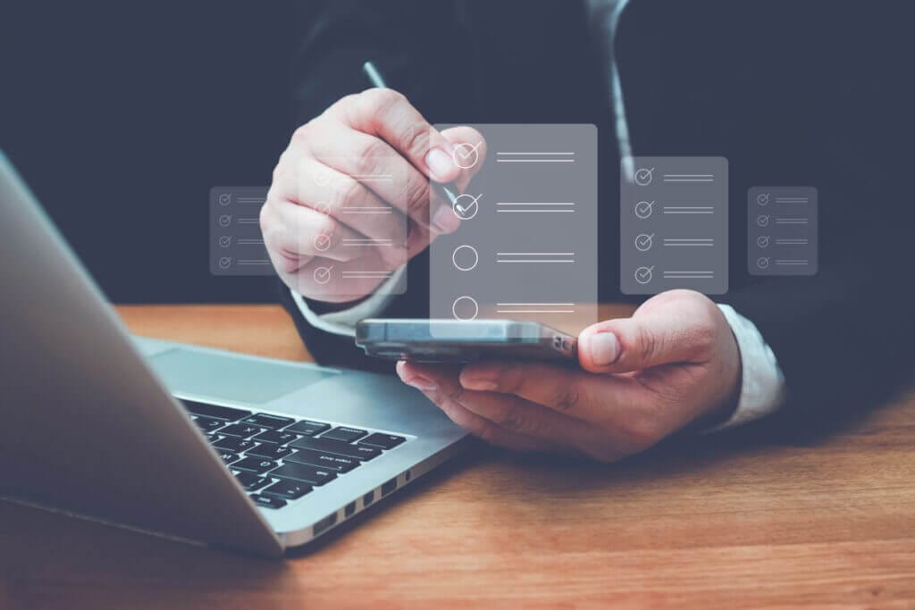 Business man using mobile device to review IT project checklist.