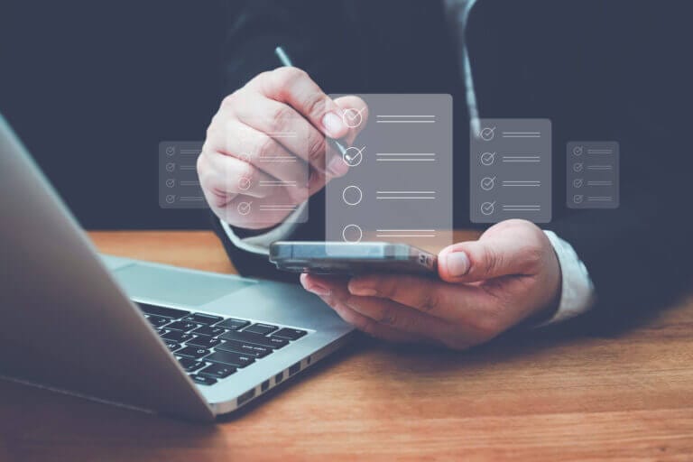 Business man using mobile device to review IT project checklist.