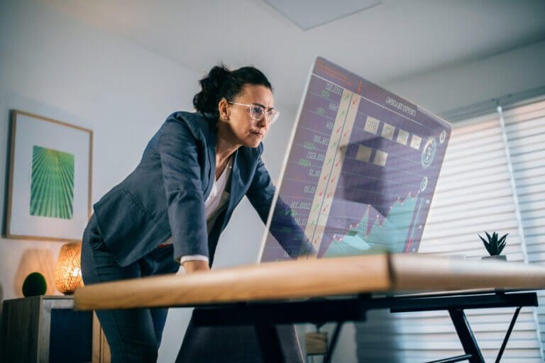 Woman reviewing IT business decisions on computer screen.