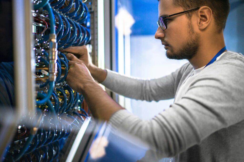 IT staff on wiring in a network closet.