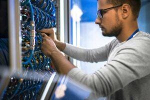 IT staff on wiring in a network closet.