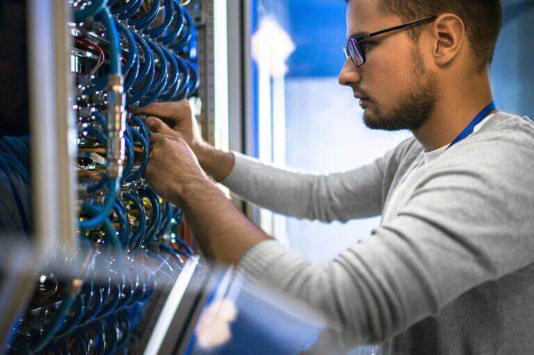 IT staff on wiring in a network closet.