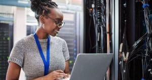 Woman working in a network/IT closet.