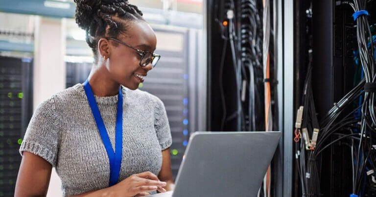 Woman working in a network/IT closet.