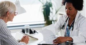 Healthcare worker reviewing paperwork with patient.