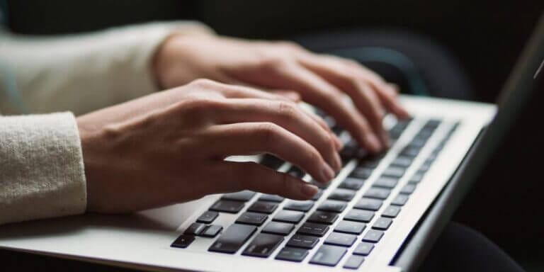 Female staff working on a laptop from home.