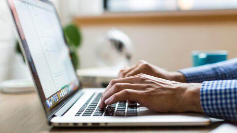 Man on a laptop working on cybersecurity policies.