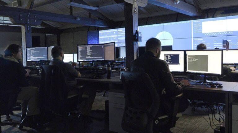 SOC room with employees working on IT projects.