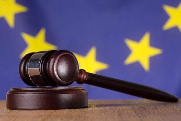 Gavel laying on table with star flag behind it.