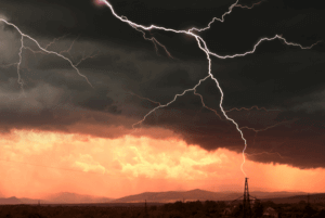 Low mountain view with lightning striking in the distance.