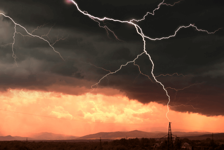 Low mountain view with lightning striking in the distance.