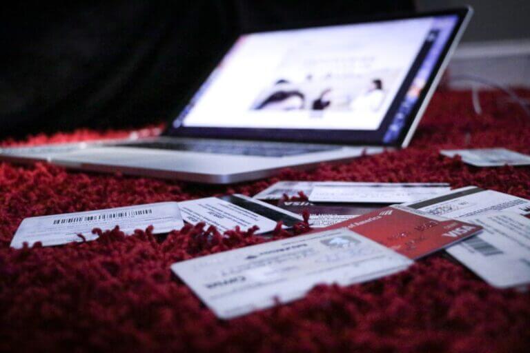 Credit cards piled up next to a computer.