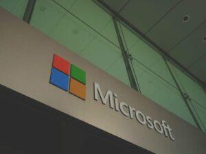 Microsoft sign on a building below a glass window.