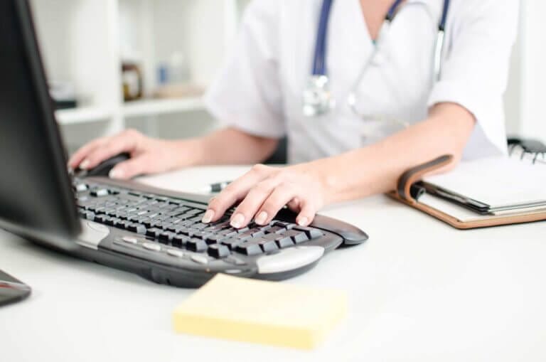 Healthcare worker using a computer in her office.