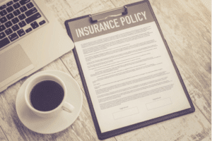 Insurance policy documents next to computer.