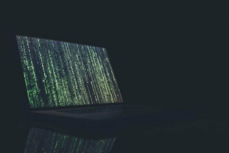 Lines of code streaming down on a laptop computer.