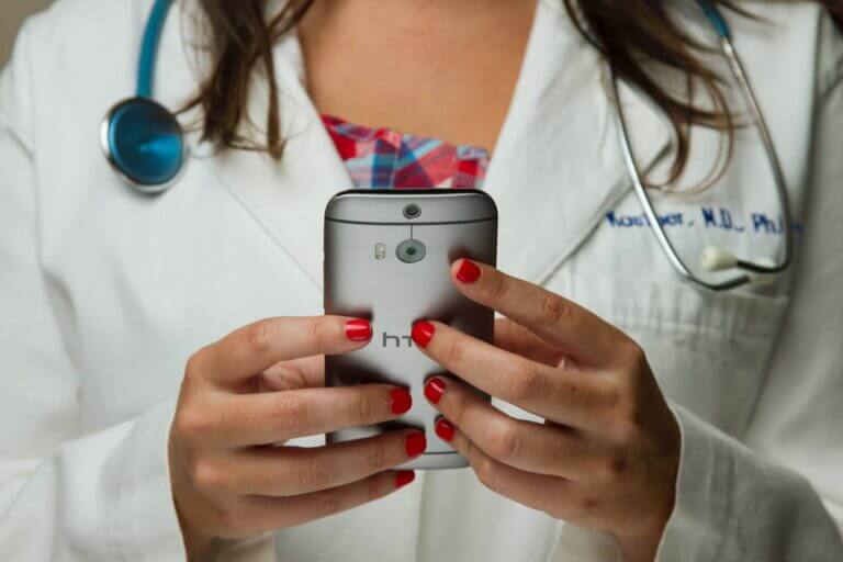 Female healthcare staff working on a mobile device.
