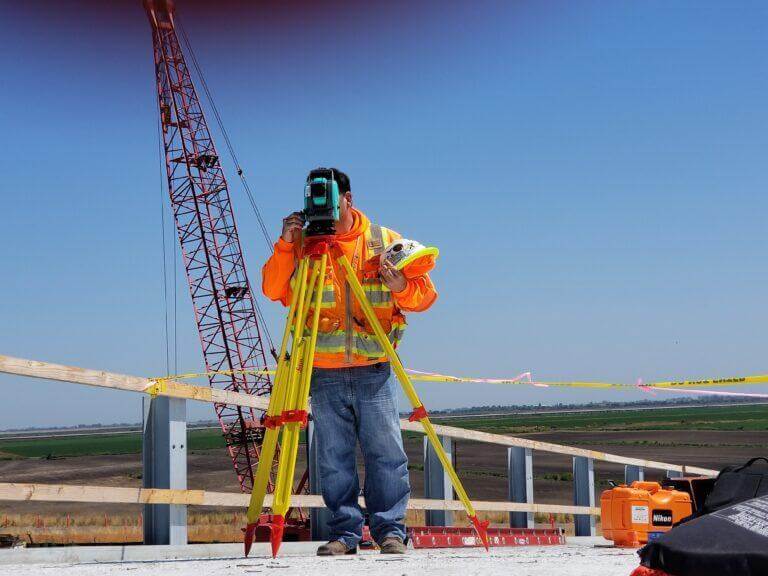 Construction worker in a orange vest working on a construction site.