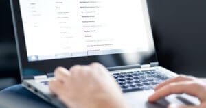 Hands typing on computer.