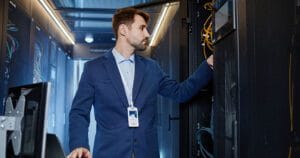 IT employee is performing maintenance in network closet.
