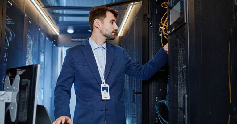IT employee is performing maintenance in network closet.