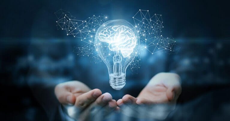 Hands holding a digital lightbulb with a graphic of a brain inside.
